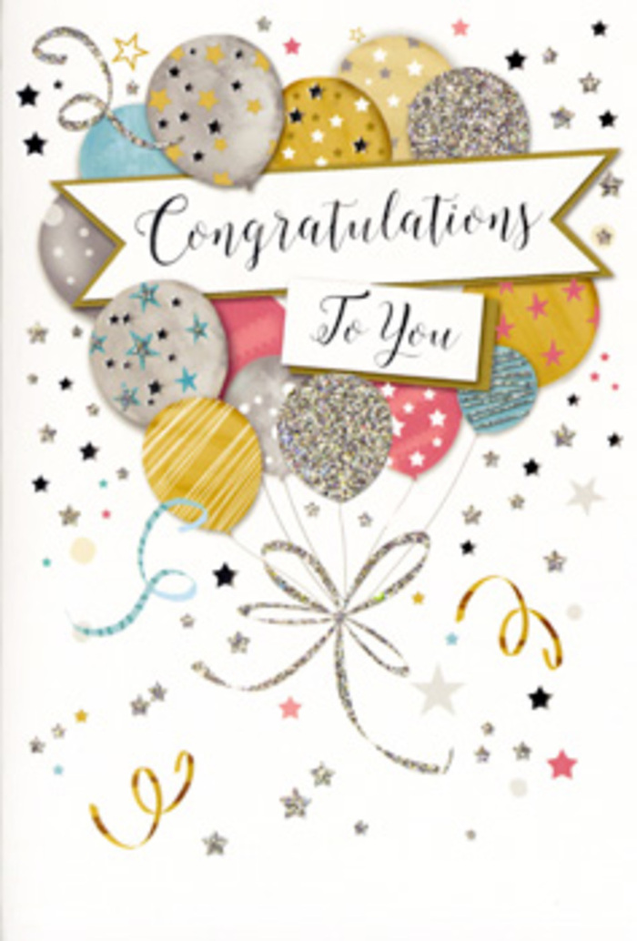 The image presents a refined congratulations card, propped upright so the full front cover is clearly visible, styled much like a celebration vignette you might find beside a fresh bouquet in a Tring living room. At the heart of the card is a lush gathering of illustrated balloons, layered in a gentle arc that fills the central space. Each balloon is softly rounded, coloured in tones of warm gold, cool silver, pale champagne, sky blue, blush pink, and misty grey, the shades blending harmoniously like evening light over Tring's rooftops. Delicate metallic details define each shape: some balloons shimmer with all-over glitter, others are circled with fine bands, and a few carry tiny star motifs, giving the impression of twinkling lights at a cosy garden party off Miswell Lane. The balloon strings flow downward in graceful, intertwined lines of gold and silver, joining at the base in a loose knot that feels hand-drawn and organic. Surrounding the balloons, scattered stars, curved ribbons, and little flecks of confetti drift across the pale background, creating a sense of motion and making the illustration feel airy and celebratory rather than busy. A soft banner stretches across the middle, its edges slightly curled as though caught in a gentle breeze, holding the message Congratulations To You in flowing, decorative calligraphy that suggests care and intention. The surface finish appears a mix of matte card and shimmering highlights, implying a lightly raised glitter that would catch the light when placed near a window in a Tring home. The overall mood is stylish yet heartfelt, a card that pairs beautifully with an elegant arrangement from Flowers Tring for marking graduations, promotions, or personal achievements that deserve a touch of glamour.